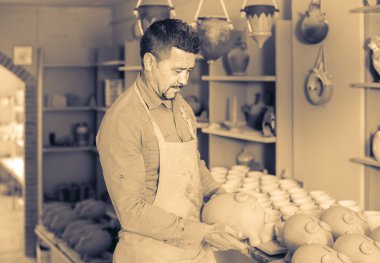 man potter holding ceramic vessels clipart