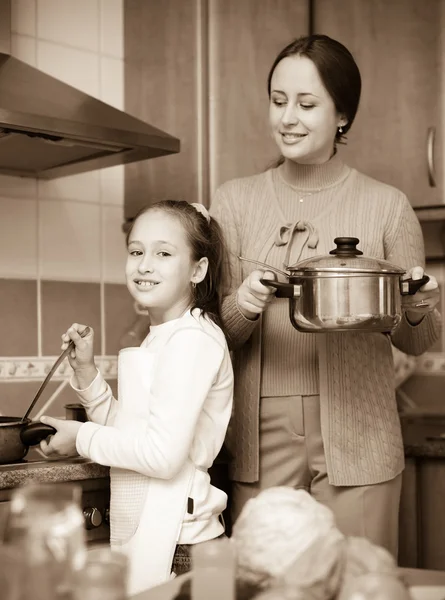 Mädchen und Mutter kochen Suppe — Stockfoto