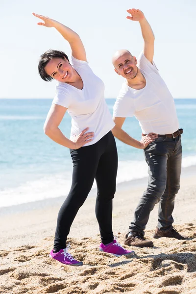 Coppia che fa yoga sulla spiaggia — Foto Stock