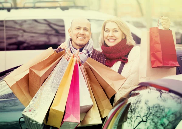 Mature couple with shopping bags — Stock Photo, Image