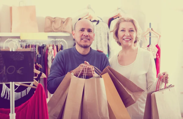 Mature spouses carrying bags with purchases — Stock Photo, Image