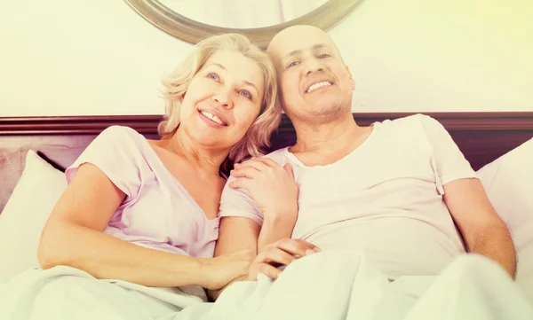 Mature adults lying in family bed — Stock Photo, Image