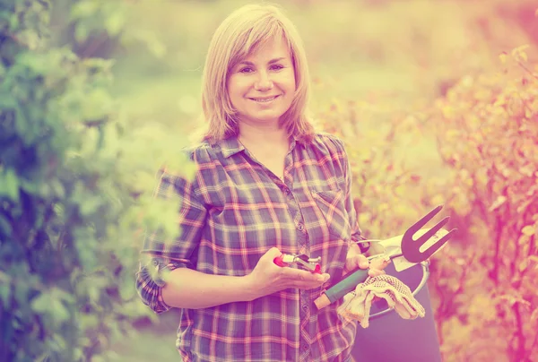 Mulher segurando ferramentas hortícolas — Fotografia de Stock