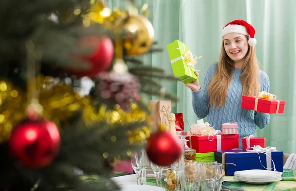 Vrouw in kerstmuts met kerst geschenken — Stockfoto