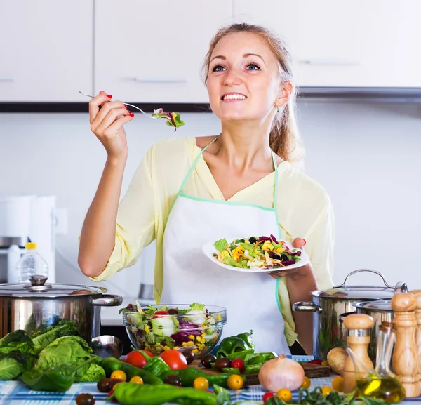 Flicka provsmakning grönsakssallad — Stockfoto