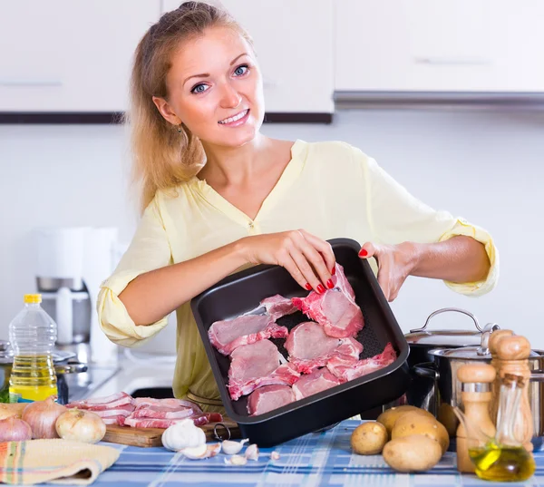 Femme au foyer cuisine avec de la viande — Photo