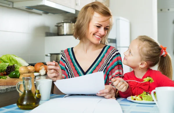 Mother working and girl eating — Stock Photo, Image