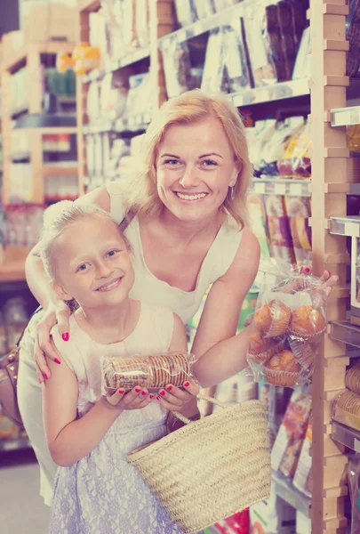 Feminino com filha escolhendo pão — Fotografia de Stock