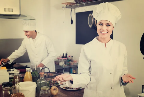 Feminino jovem cozinheiro vestindo uniforme de trabalho — Fotografia de Stock