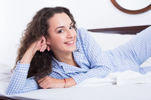 Brunette vrouwelijke loungen in bed — Stockfoto