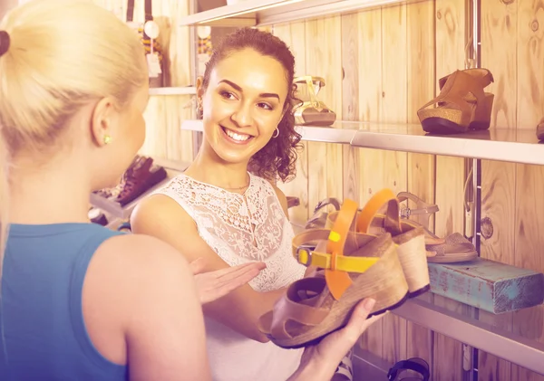 Due ragazze che scelgono le scarpe nel negozio — Foto Stock