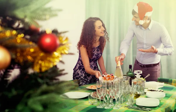 Jovem casal servindo mesa de Ano Novo — Fotografia de Stock