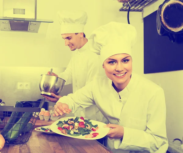 Vrouwelijke chef die verse salade serveert — Stockfoto