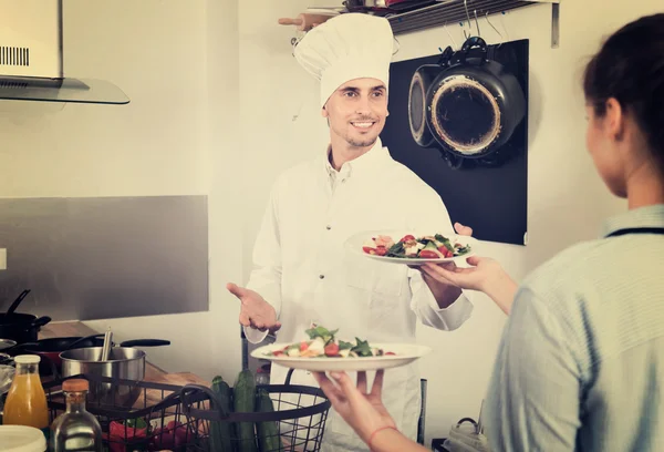 Cuisinier donnant à la serveuse salade — Photo