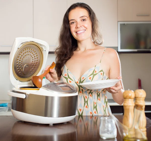 Happy girl cooking soup with multicooker — Stock Photo, Image