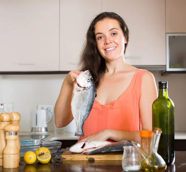 Frau kocht Fisch in der Küche — Stockfoto