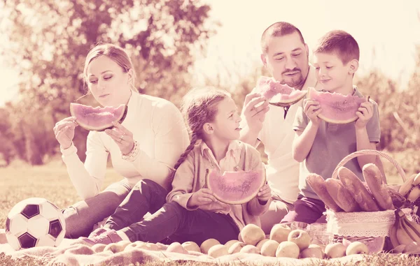 Familia disfrutando de la sandía en el picnic — Foto de Stock