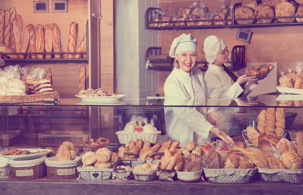 Friendly women at bakery display — Stock Photo, Image