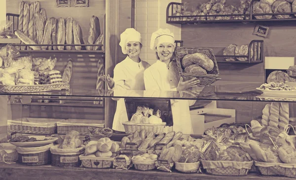 Glimlachende vrouwen verkopen verse gebak — Stockfoto