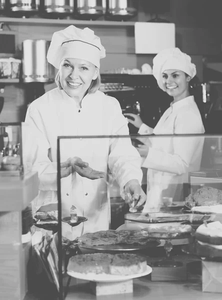 Cafe staff offering cakes — Stock Photo, Image