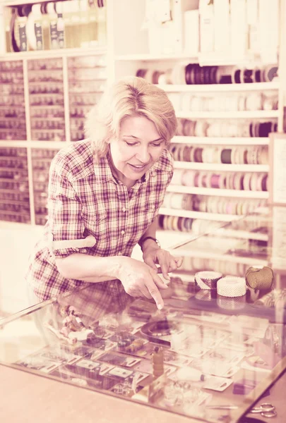 Femme mûre près de vitrine en verre n boutiqu — Photo