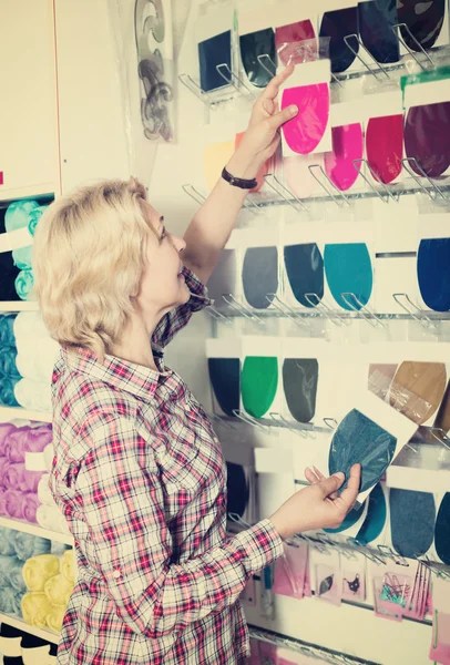 Жінка вибирає різні текстильні латки — стокове фото