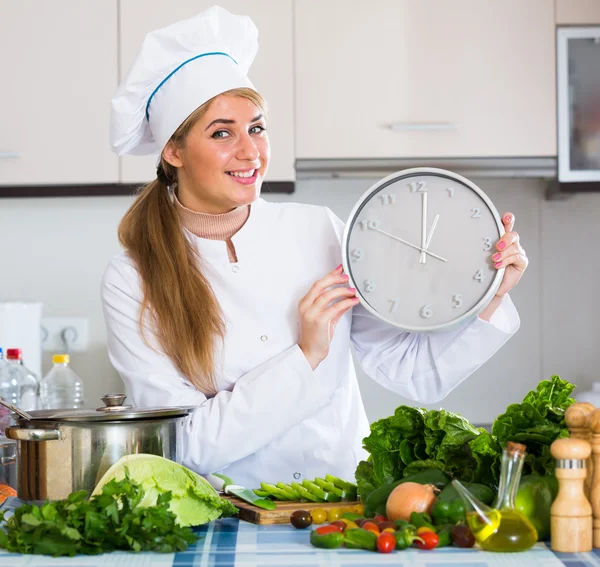 Девушка в форме шеф-повара с часами и овощами — стоковое фото