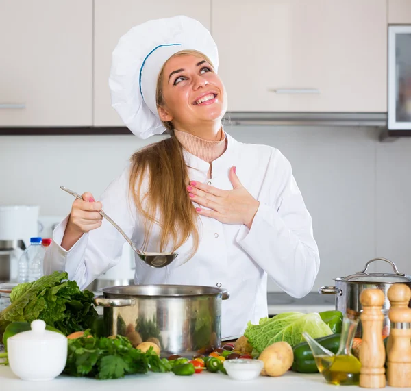 Счастливая женщина-повар готовит овощи — стоковое фото