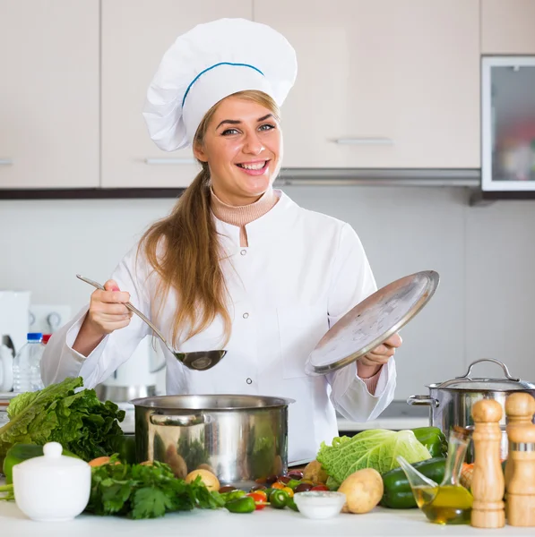 Happy female cook preparing veggies — Stock Photo, Image