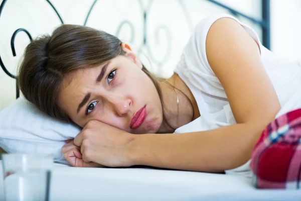 Ordinary teenage girl with sad look in bed — Stock Photo, Image