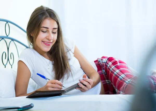 Portrait of girl putting dreams in notepad — Stock Photo, Image