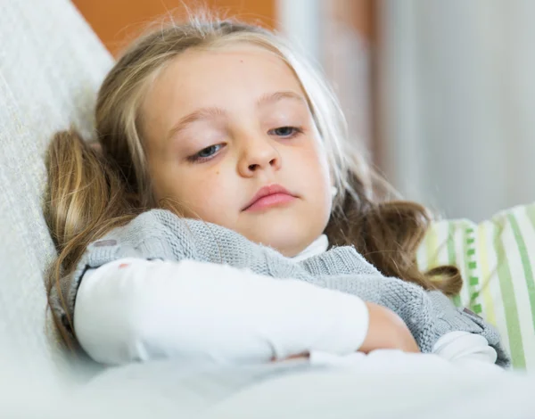 Miserable female child posing in couch — Stock Photo, Image