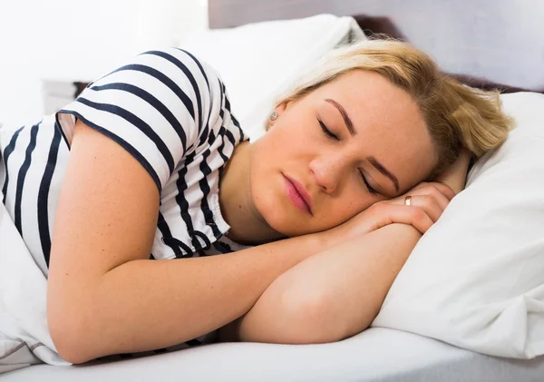 Chica durmiendo con pigamas rayados en la cama —  Fotos de Stock