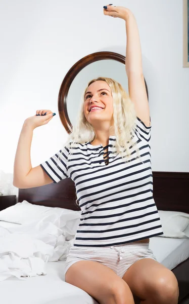 Blonde die zich uitstrekt in bed — Stockfoto