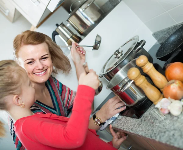 Anne ve küçük kızı çorba tatma — Stok fotoğraf