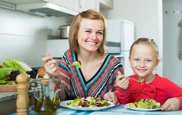 Mãe e filha comer salada de legumes — Fotografia de Stock