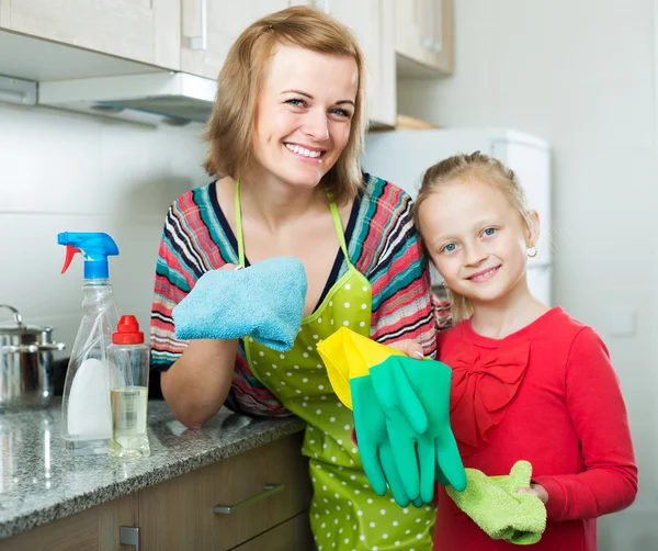 Chica ayudando a la madre desempolvar muebles —  Fotos de Stock