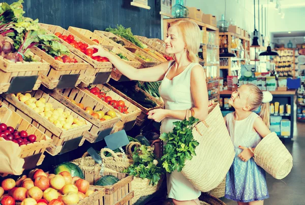 Felice madre con figlia shopping varie verdure — Foto Stock