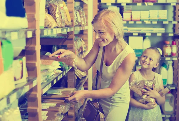 Жінка і дівчина із задоволенням купують макарони — стокове фото