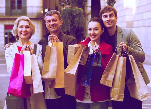 Adult family of four with shopping bags — Stock Photo, Image