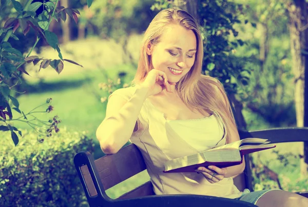 Vrouw leesboek in park op zonnige dag — Stockfoto