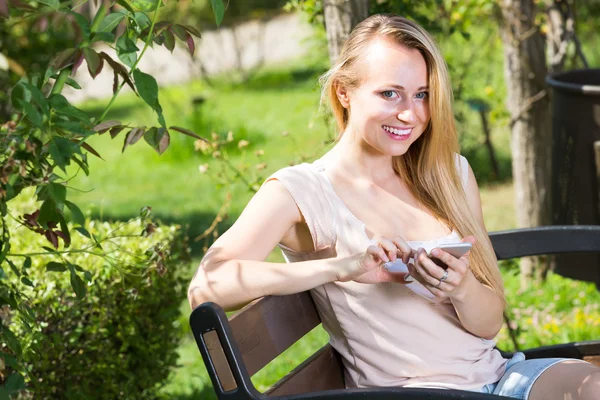 Kadın ile bahçe içinde smartphone — Stok fotoğraf