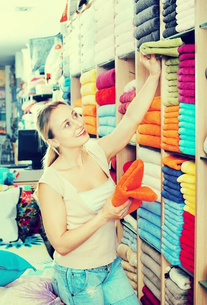 Jonge vrouw kopen zachte handdoeken — Stockfoto