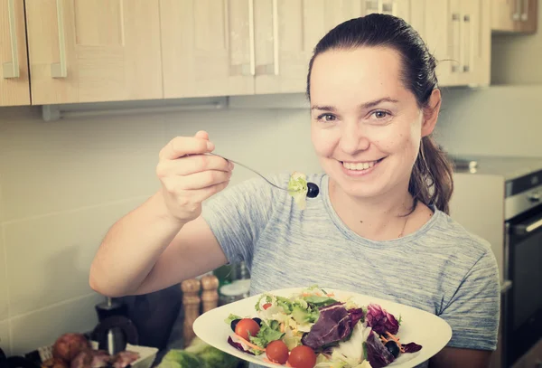 Leende kvinna äter sallad — Stockfoto