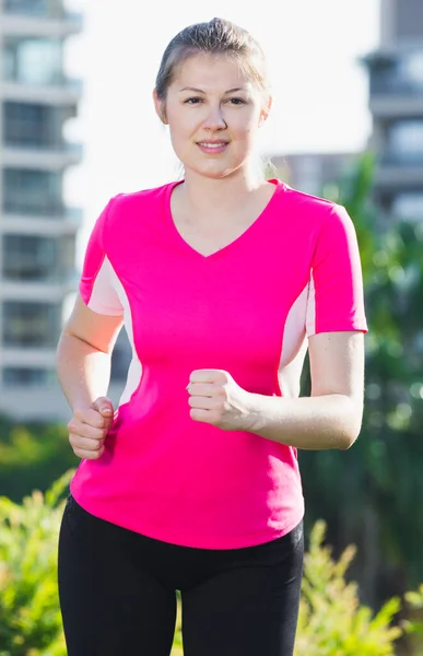 Młoda dziewczyna w różowym T-shirt jest jogging — Zdjęcie stockowe