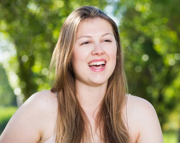 Mädchen lacht, während sie auf Bank sitzt — Stockfoto