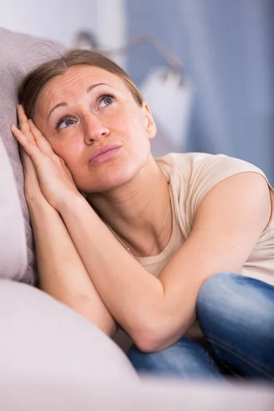 Mujer triste sentada en el sofá —  Fotos de Stock