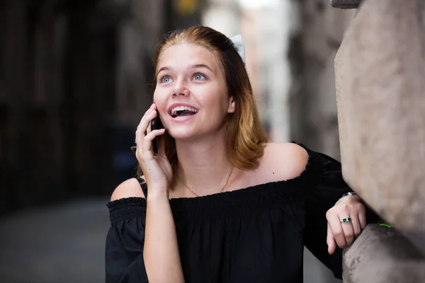 Jovem positivo feminino falando por telefone — Fotografia de Stock