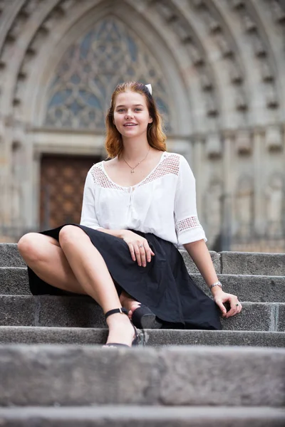 Young positive female sitting on stone stairs — Stock Photo, Image