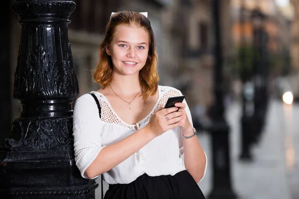 Portrét usměvavé dívky pomocí mobilního telefonu — Stock fotografie